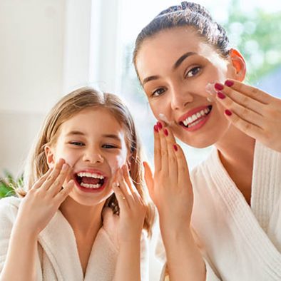 Mother and daughter caring for skin